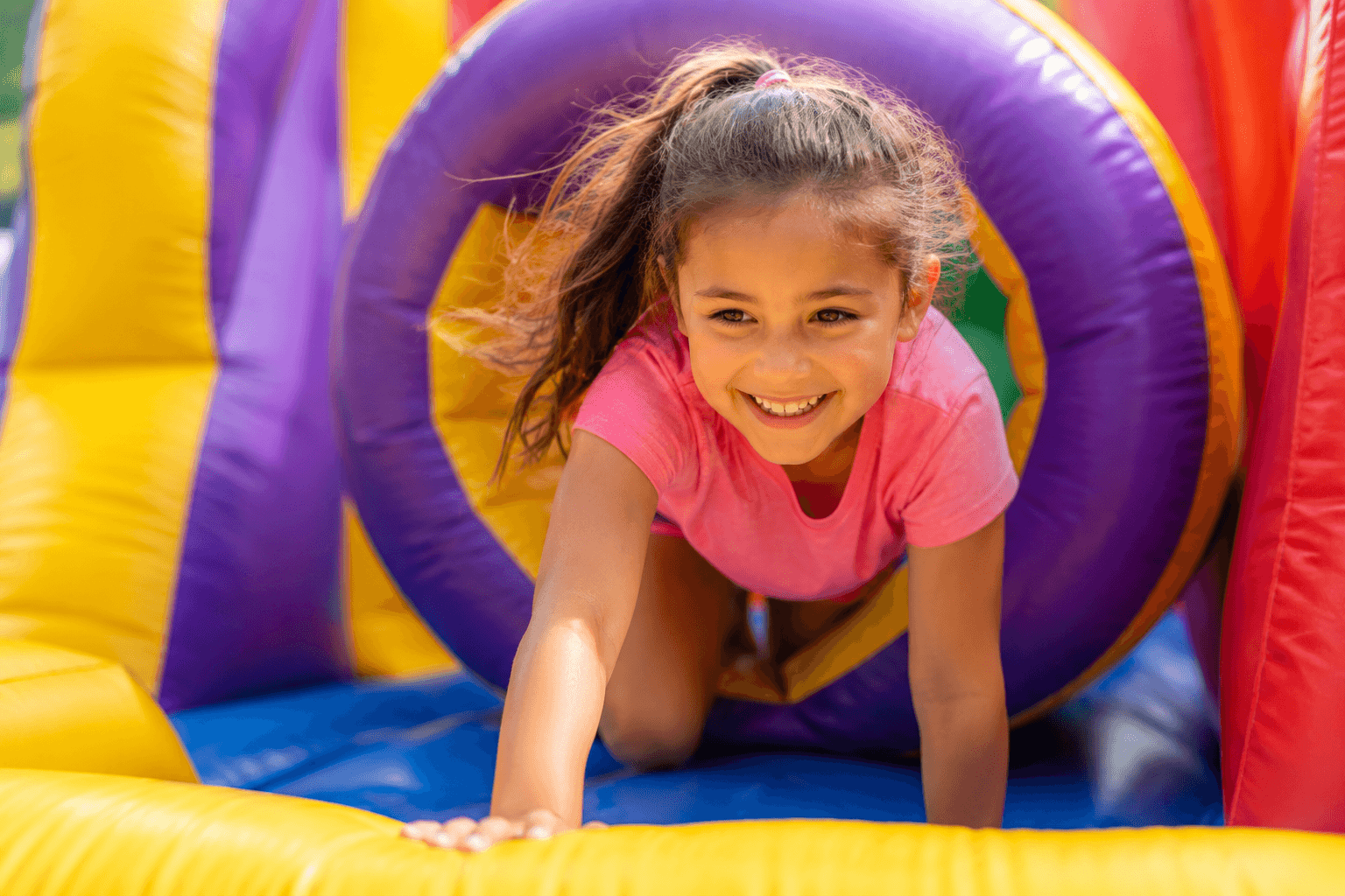 Child playing in a Bouncy B's inflatable rental at a community event